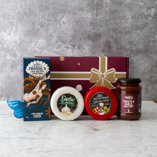 Grey background image of the Truckle Garlic Selection Box including garlic inspired cheese truckles, tomato and garlic chutney, and sea salted crackers.